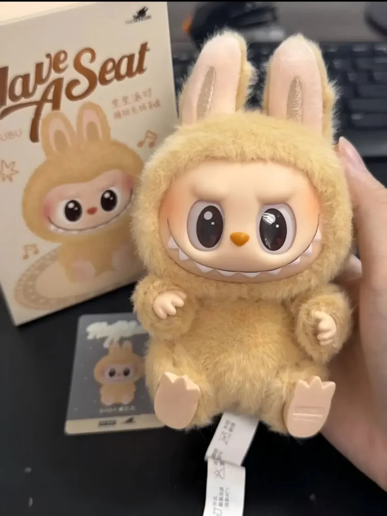 Flat-lay of Baba Labubu box contents figure, inner bag, character card
