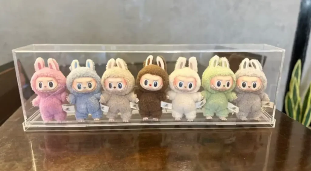 Baba Labubu centered in an acrylic display shelf with complementary figures